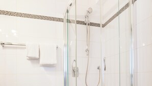A modern bathroom with a glass-enclosed shower, a toilet, and a sink. - Union Hotel by TM (Dortmund)