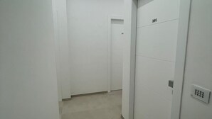 A hallway with white walls, a tiled floor, and a door marked with the number 301. - B&B Corso 219 (Montesilvano)