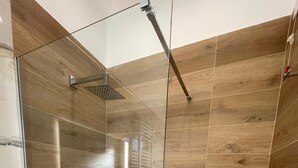 A modern shower area with a glass enclosure, a handheld showerhead, and a wall-mounted rain showerhead. - B&B Corso 219 (Montesilvano)