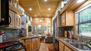 A spacious kitchen with wooden cabinets, a central island, and a large window providing natural light.