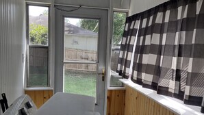 Pieni keittiö, jossa on liesi, ikkuna ja kattotuuletin.