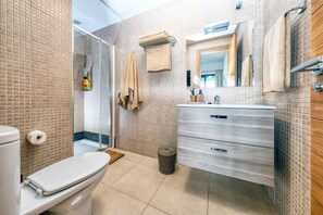 Bathtub, hair dryer, towels, toilet paper