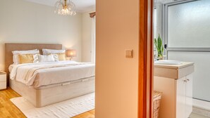 A bedroom with a bed, bedside lamps, and a nightstand. - Costa do Sol, a Home in Madeira (Funchal)