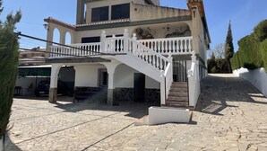 A two-story house with a white staircase leading to a balcony. - Granada Sights (AN)