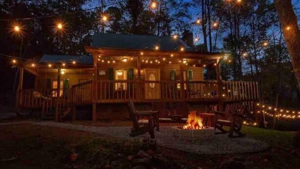 Una baita con veranda, un braciere e luci a stringa.