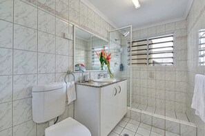 A bathroom with a toilet, sink, and shower.