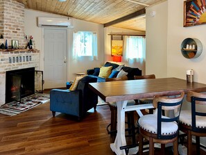A cozy living room with a fireplace, a dining table, and a sofa. - Lookout Cabin - Prescott Cabin Rentals (Prescott)