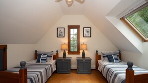 Ein Schlafzimmer mit zwei Betten, einem Fenster und einem Deckenventilator.