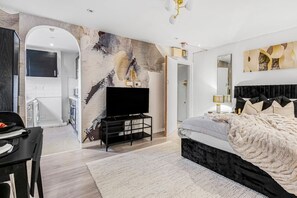 Relax in a spacious room with a large bed, flat-screen TV, and dining area.