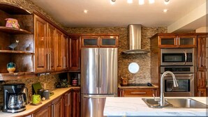 A modern kitchen with wooden cabinets, a stainless steel refrigerator, a built-in oven, and a microwave. - A family-friendly getaway, with outdoor pool and beautiful view!
(Newmarket)