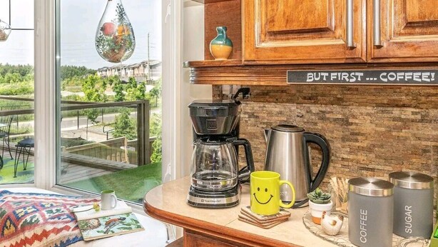 A kitchen with a coffee maker, a mug, and a sign that says "BUT FIRST... COFFEE!". - A family-friendly getaway, with outdoor pool and beautiful view!
(Newmarket)