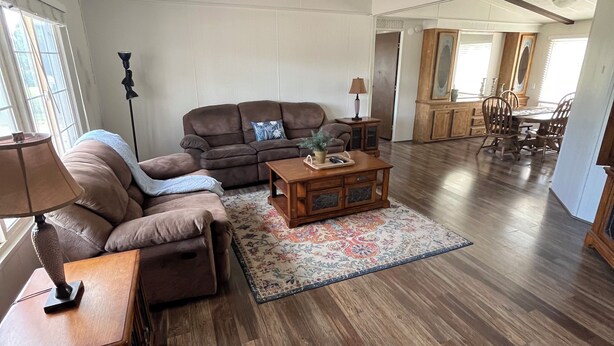 A spacious living room with a brown leather sofa, a wooden coffee table, and a patterned rug. - Comfortable home, great location (Escalante)