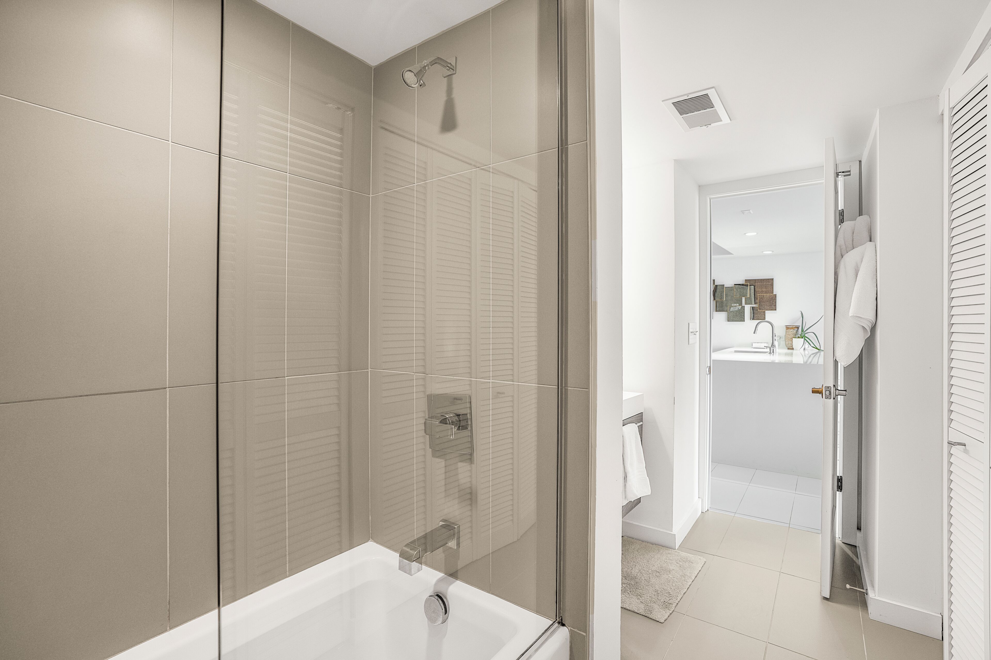 A modern bathroom with a glass-enclosed shower, a standalone bathtub, and a walk-in shower with a glass door.