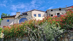 A traditional stone building with a large arched window and a balcony.