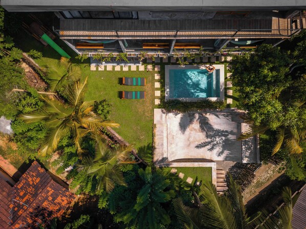An aerial view of a resort with a swimming pool, lounge chairs, and lush greenery. - Gaia Soul  (Maaliyadda)