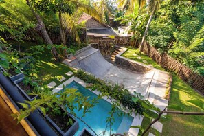 A backyard with a swimming pool, a small garden, and a wooden house. - Gaia Soul  (Maaliyadda)