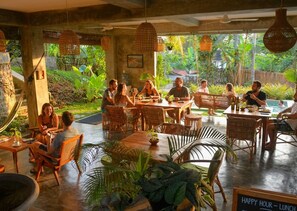 A restaurant with outdoor seating, wicker furniture, and lush greenery. - Gaia Soul  (Maaliyadda)