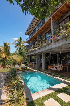 A modern house with a swimming pool, outdoor seating, and lush greenery. - Gaia Soul  (Maaliyadda)