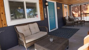 A covered porch with a wicker sofa, a blue door, and wicker furniture. - Whole House in N. Denver with hot-tub (Denver)