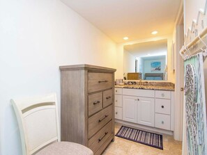 A compact kitchen with white cabinets, a wooden cabinet, and a countertop with a sink. - Renovated Saddlebrook 1st Floor Condo 2bd/2ba (Wesley Chapel)
