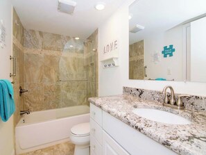 Un bagno con vasca, doccia, lavandino e wc.