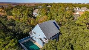 An aerial view of a house with a swimming pool surrounded by dense trees. - SemiSecluded OBX Beach House, Heated Pool&Hot Tub, Beach Access, Pinball, Arcade (Corolla)