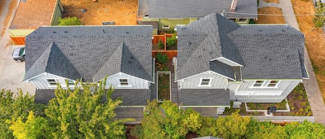 A residential area with two houses featuring grey roofs and white trim.