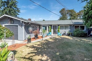 A single-story house with a garage, a covered porch, and a well-maintained lawn.