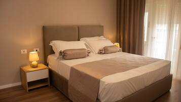 A neatly made bed with a headboard, a bedside lamp, and a nightstand.