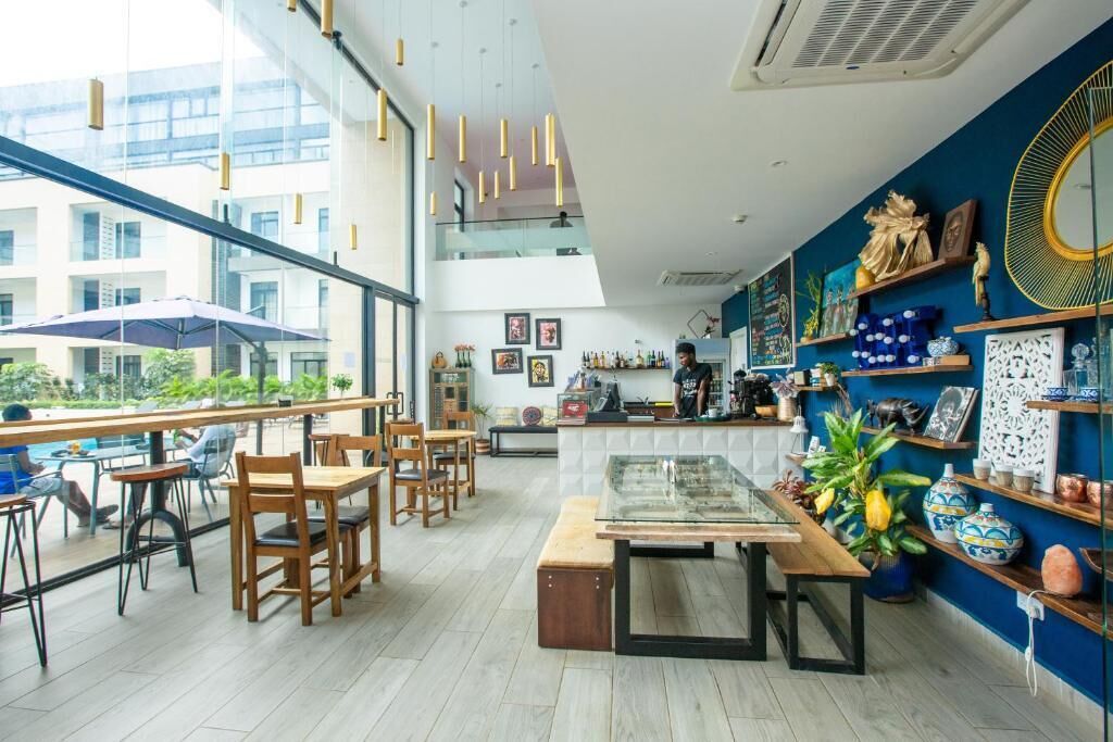A modern cafe with wooden furniture, a glass display case, and decorative items on the walls.