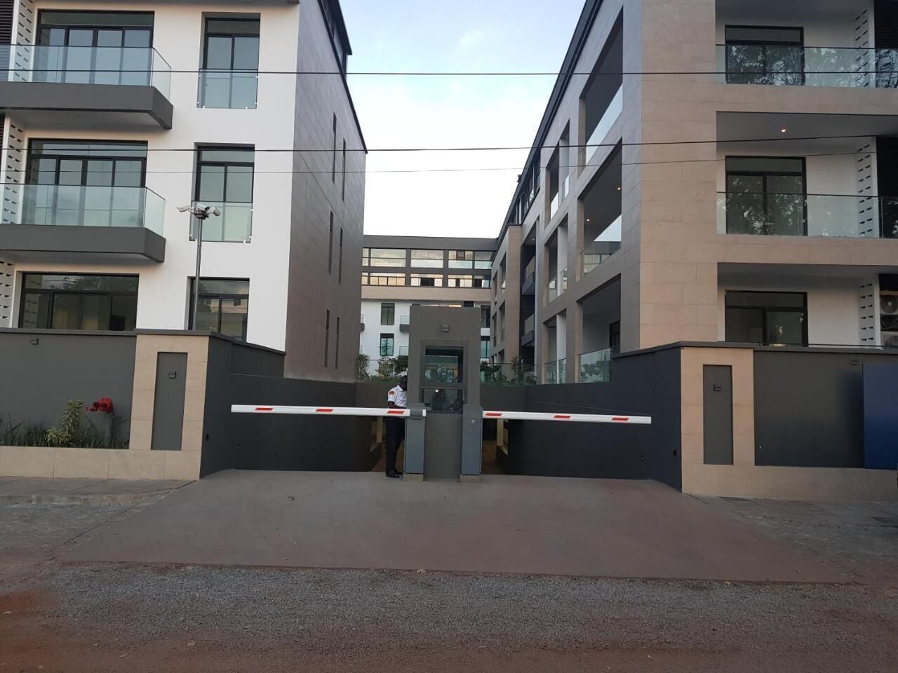 Een modern gebouw met een hekpoort, meerdere verdiepingen en balkons.