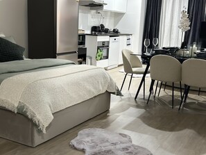 A modern bedroom with a large bed, a small desk, and a chair.