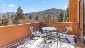 A wooden deck with a round table and four chairs, overlooking a mountainous landscape. - One block to Keystone Conference Ctr: 2-BR townhouse, king beds, pool, hot tub (Keystone)