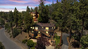 A two-story house with a staircase leading to the upper level, surrounded by dense forest. - Cozy Cabin Nestled in the Wilderness - 1 mile from Bear mountain (Big Bear Lake)