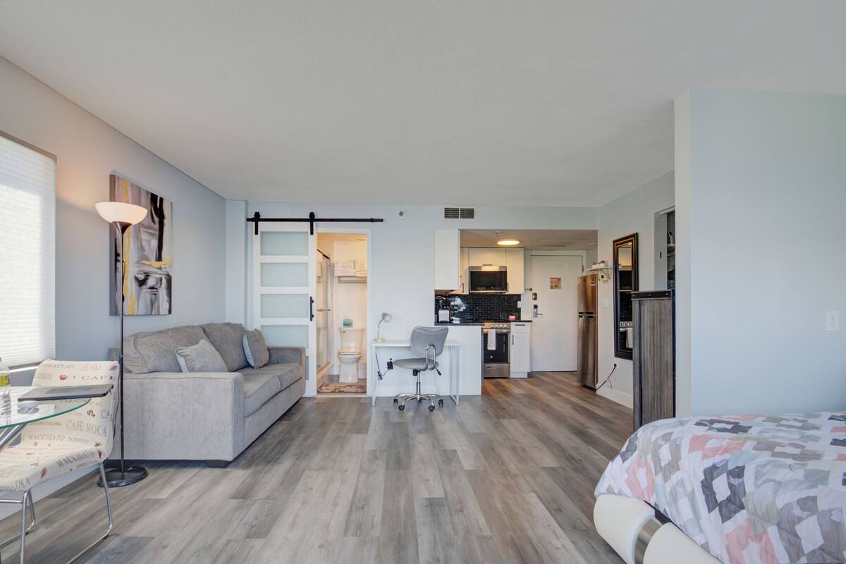 A modern apartment with a kitchenette, a dining area, and a living room.