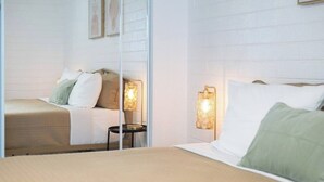 Une chambre d’hôtel avec un lit, une petite table et des lampes fixées au mur.