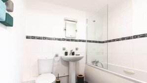 A bathroom with a toilet, sink, and shower.