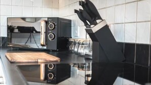 A kitchen with a black countertop, a toaster, and a knife block.