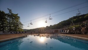 Ein Schwimmbecken mit Liegestühlen und einer Steinmauer.