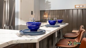 Eine moderne Küche mit Marmorarbeitsplatte, Edelstahlgeräten und blauen Schüsseln auf Tellern.