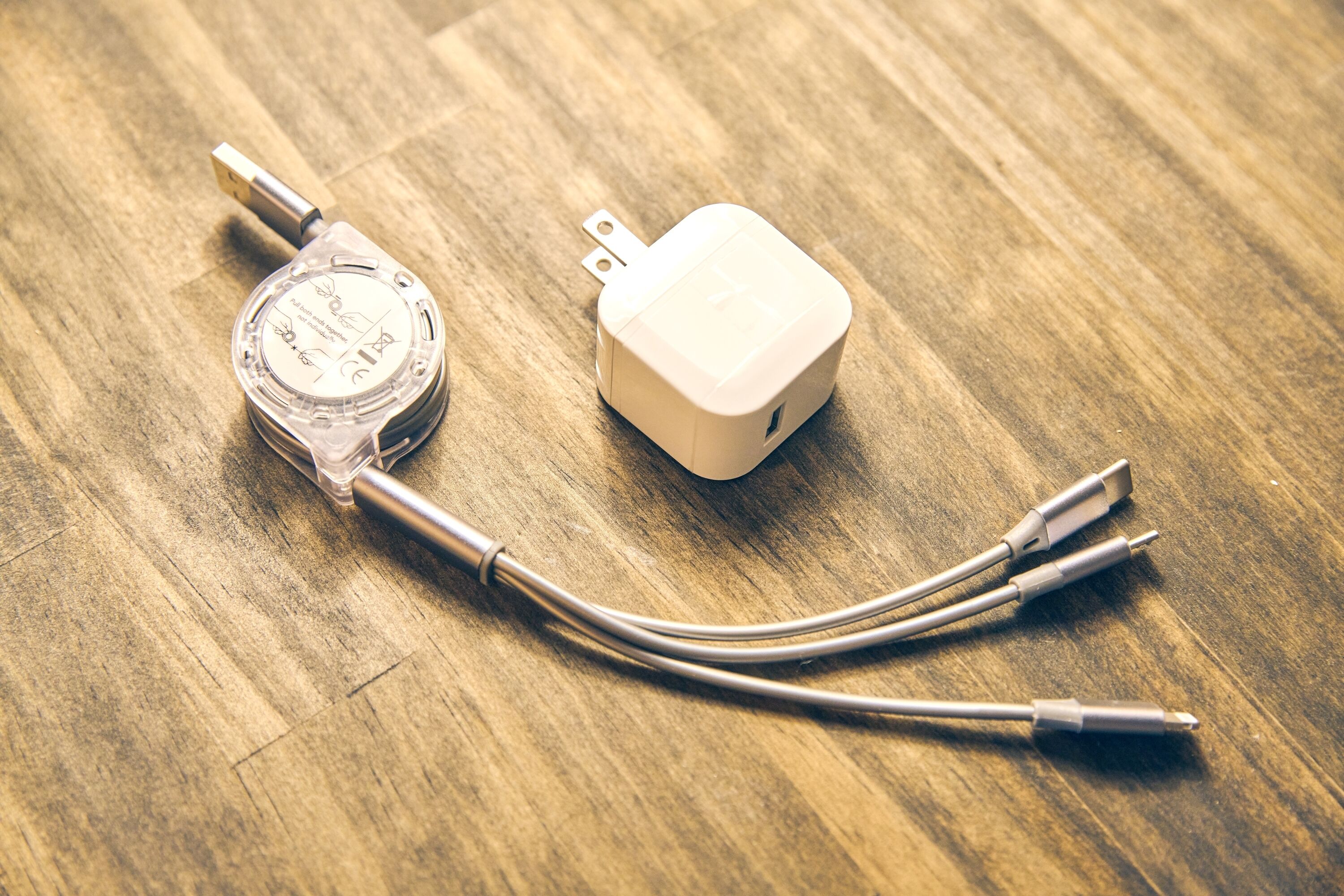 A power adapter with a cable on a wooden surface.