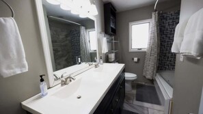 Bathtub, hair dryer, towels, shampoo