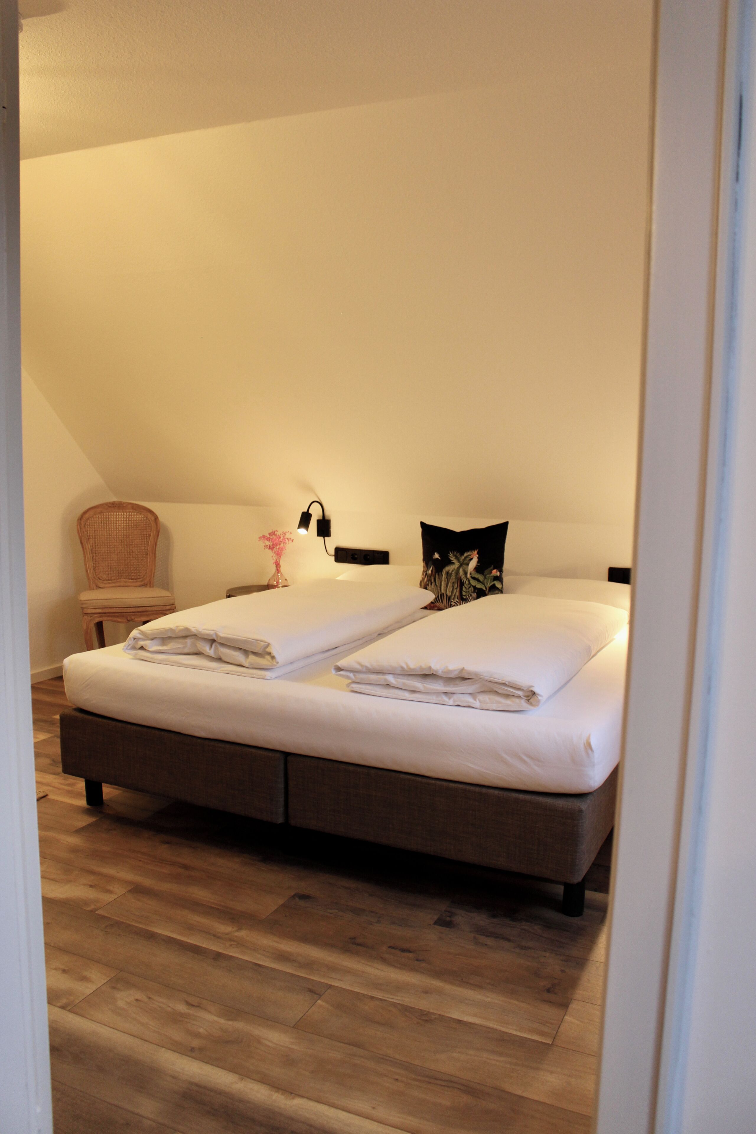Ein Schlafzimmer mit einem Bett, einem Sessel und einem Nachttisch.