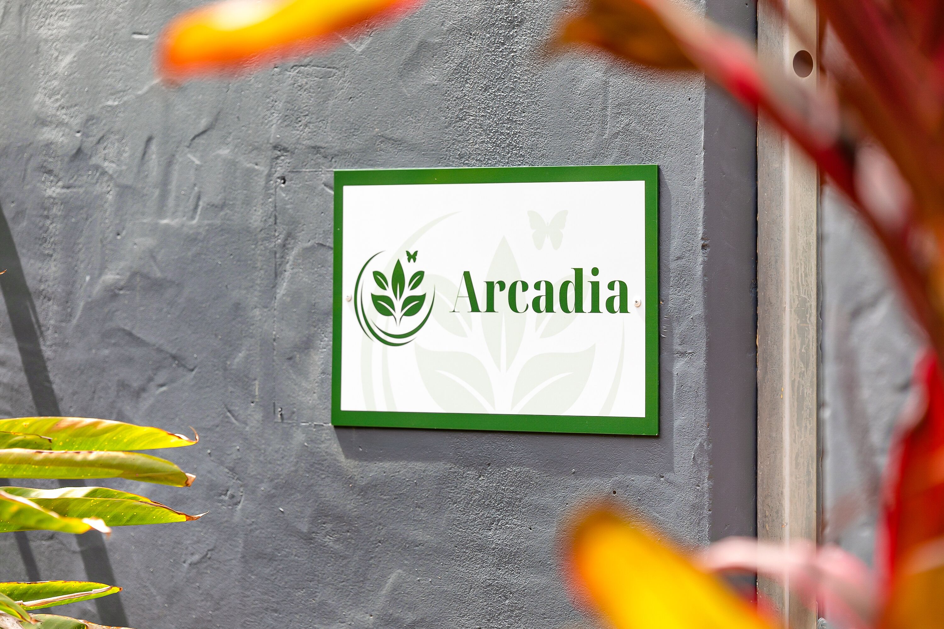 A sign with the name "Arcadia" and a logo featuring a leaf and butterfly.