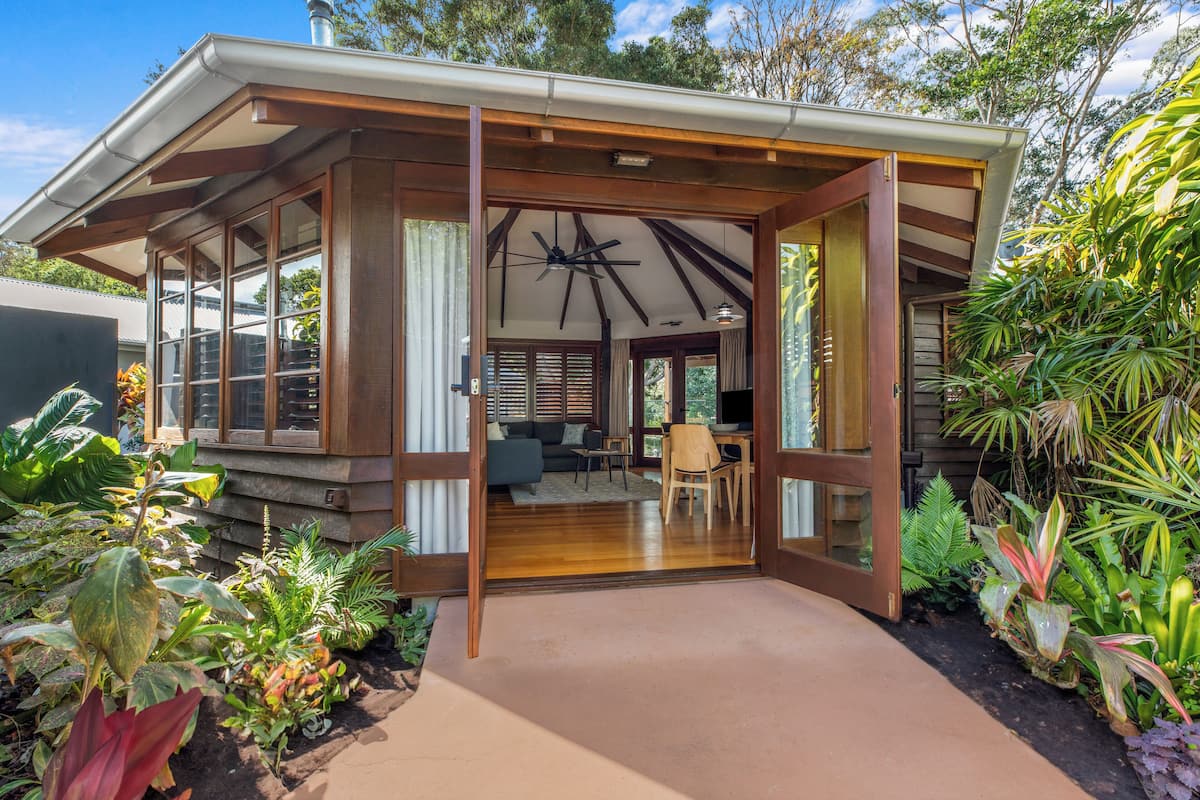A modern house with a covered porch, large windows, and a dining area.