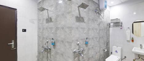 A modern bathroom with grey marble walls, a shower, a toilet, and a sink.