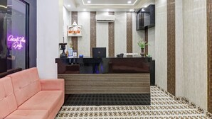 A reception area with a black desk, a computer, and a neon sign. - Hotel The Rasa Kanti Nagar  (New Delhi)