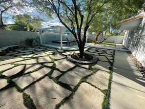 Enjoy a peaceful retreat in an outdoor space surrounded by a tree and a low wall.