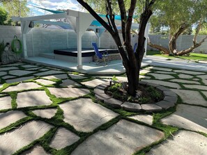 Stroll through the serene outdoor space, surrounded by a tree and a beautifully arranged stone pathway.