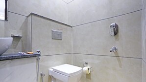 A bathroom with a toilet, a shower, and a sink. - Hotel Mannat bhera enclave (New Delhi)
